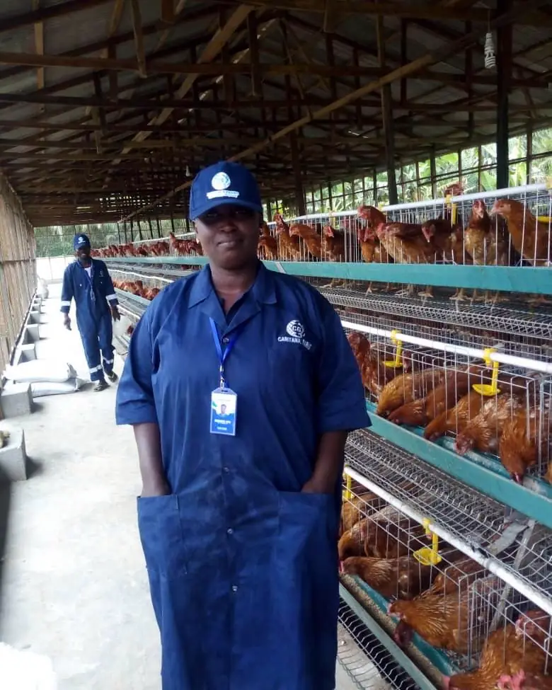 A team member in a Caritana Farms smock and ID badge
